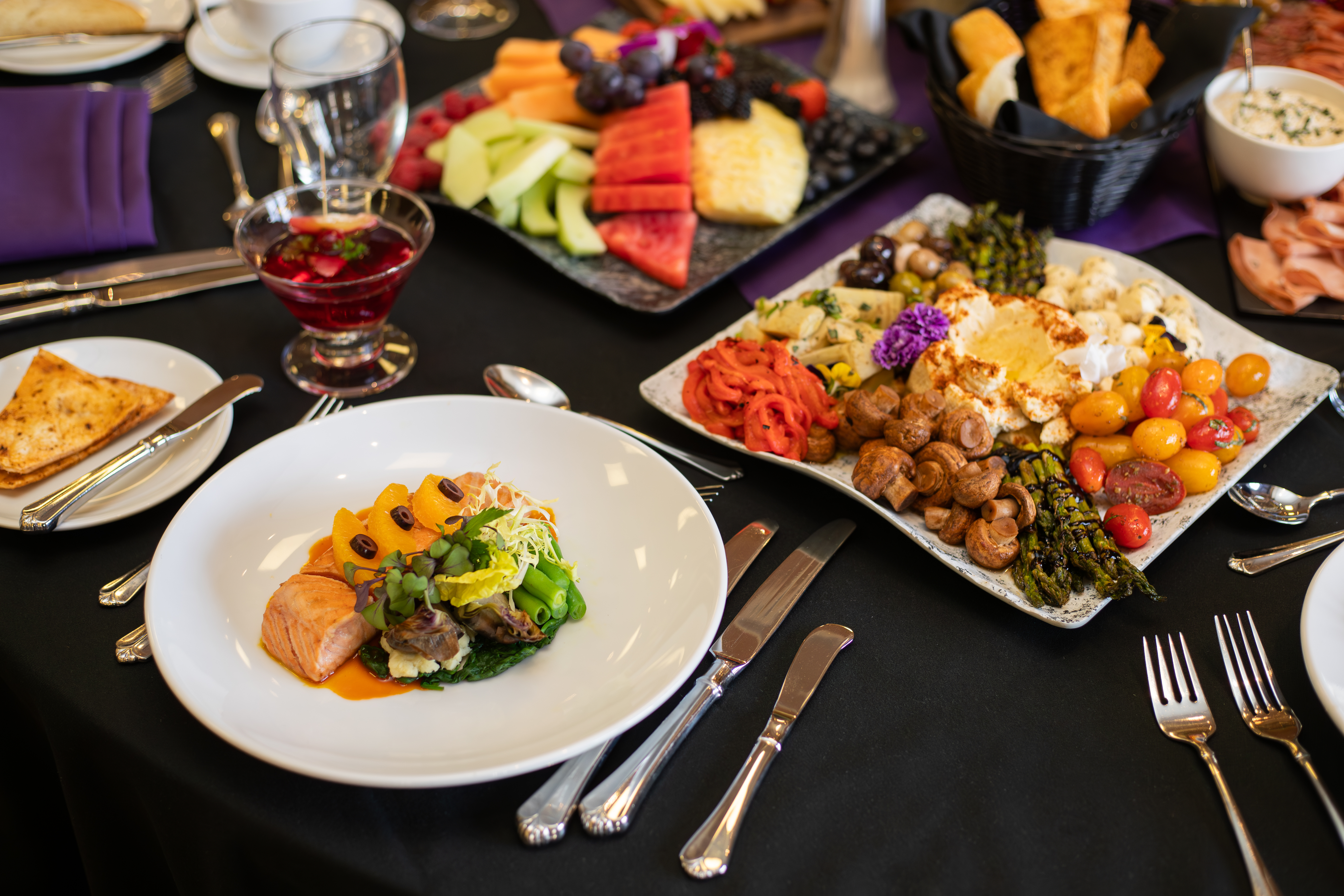 A plated dish of salmon, on a table filled with various items